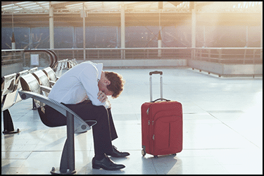 בן אדם עצוב/עייף עם מזוודה בשדה התעופה