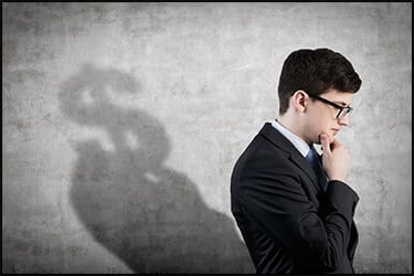 Businessman thinking about the VIP service cost. In his shadow you see a big dollar sign
