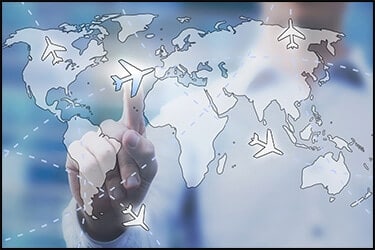 Bluish map of the world on a glass window. Man is pointing on a plane while other planes are moving around the map