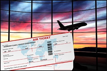 כרטיסי טיסה ומטוס ברקע של שקיעה צבעונית