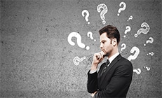 Man thinking with many question marks around his head